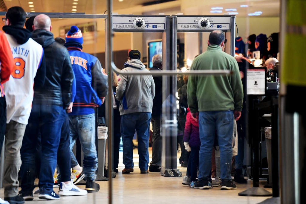 A security line with metal detectors and cameras on top of them