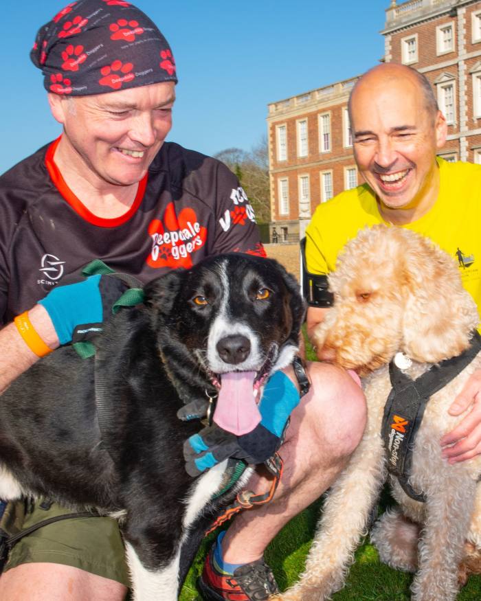 Deepdale Doggers founder Clarke Midgley with his dog Jasper, next to Ian Bavin and Fudge, in front of Wimpole Hall