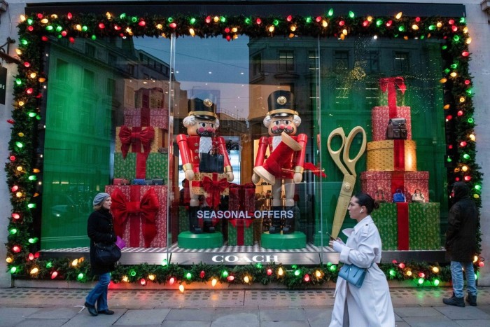 Shoppers pass a festive window display at the Coach store in Regent Street in London 