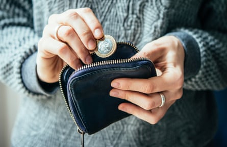 Hands holding coin and small money pouch