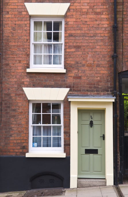 Small townhouse with green front door and cream-coloured frame and white sash windows in Ludlow, Shropshire