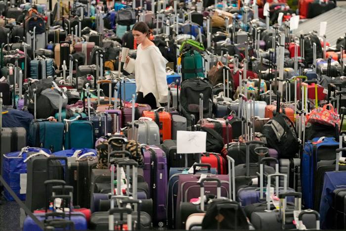 A woman walks through unclaimed bags at Southwest Airlines baggage claim at Salt Lake City 