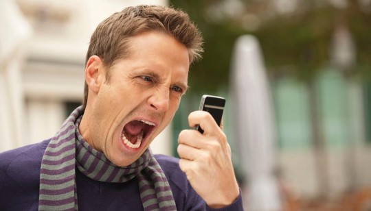 Angry man looking at phone