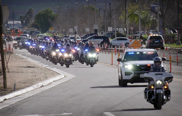 A law enforcement procession escorts the body of slain Riverside...