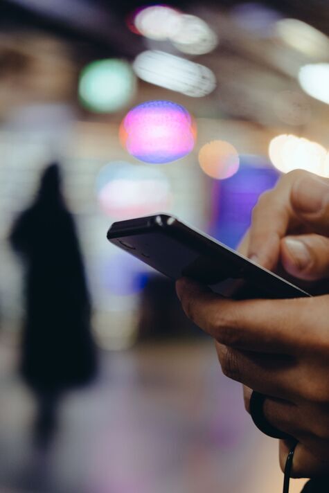 Image of city illumination and people using smartphones