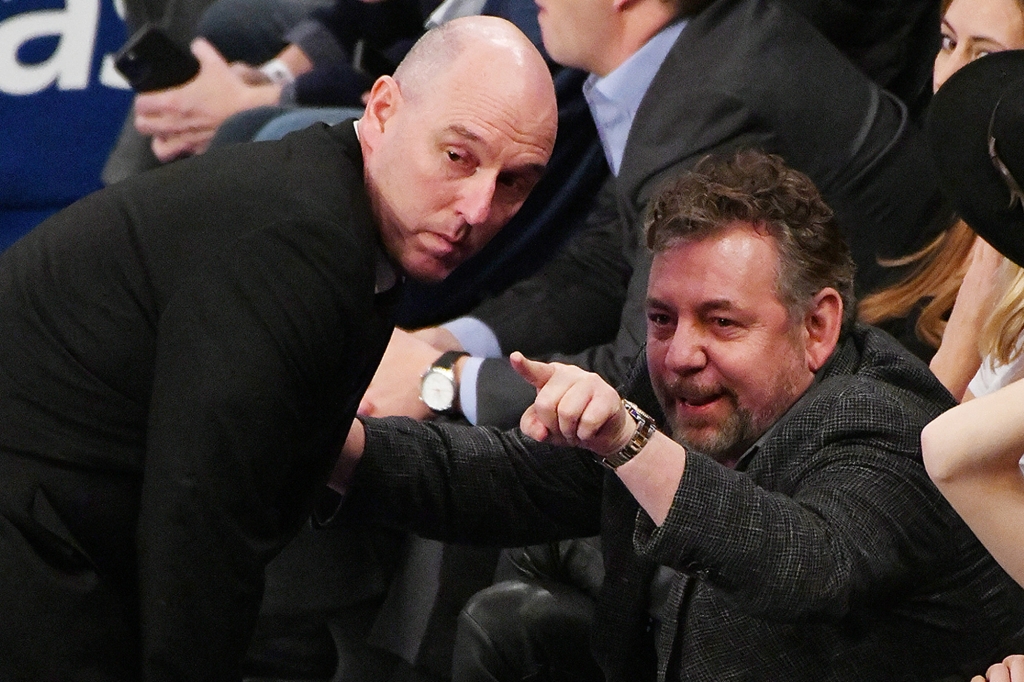 James Dolan sitting and pointing at something alongside another man 