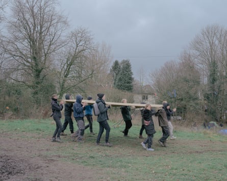 Activists carry a wooden board to build a barricade to protect themselves from eviction