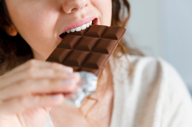 Young woman eating chocolate at home