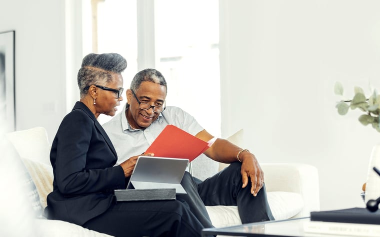 A financial advisor meets with an older man at his home.