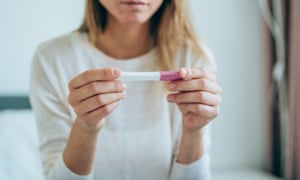 Woman looking at pregnancy test at home.