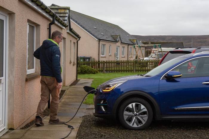 man charging an electric vehicle