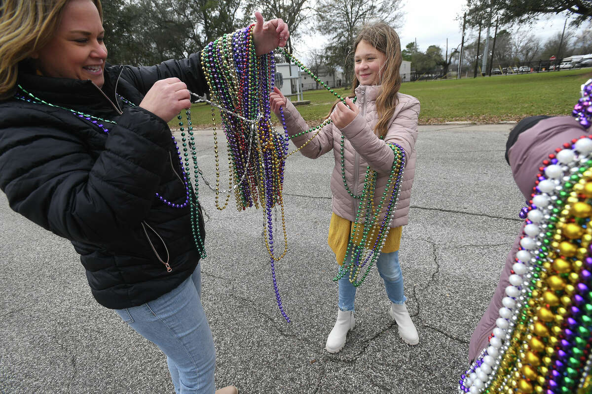 Kayla Reynolds and daughter Brilee separate their beads as they get ready to join in the Munchkin Parade during Mardi Gras on the Sabine Saturday in Orange. Photo made Saturday, February 11, 2023 Kim Brent/Beaumont Enterprise