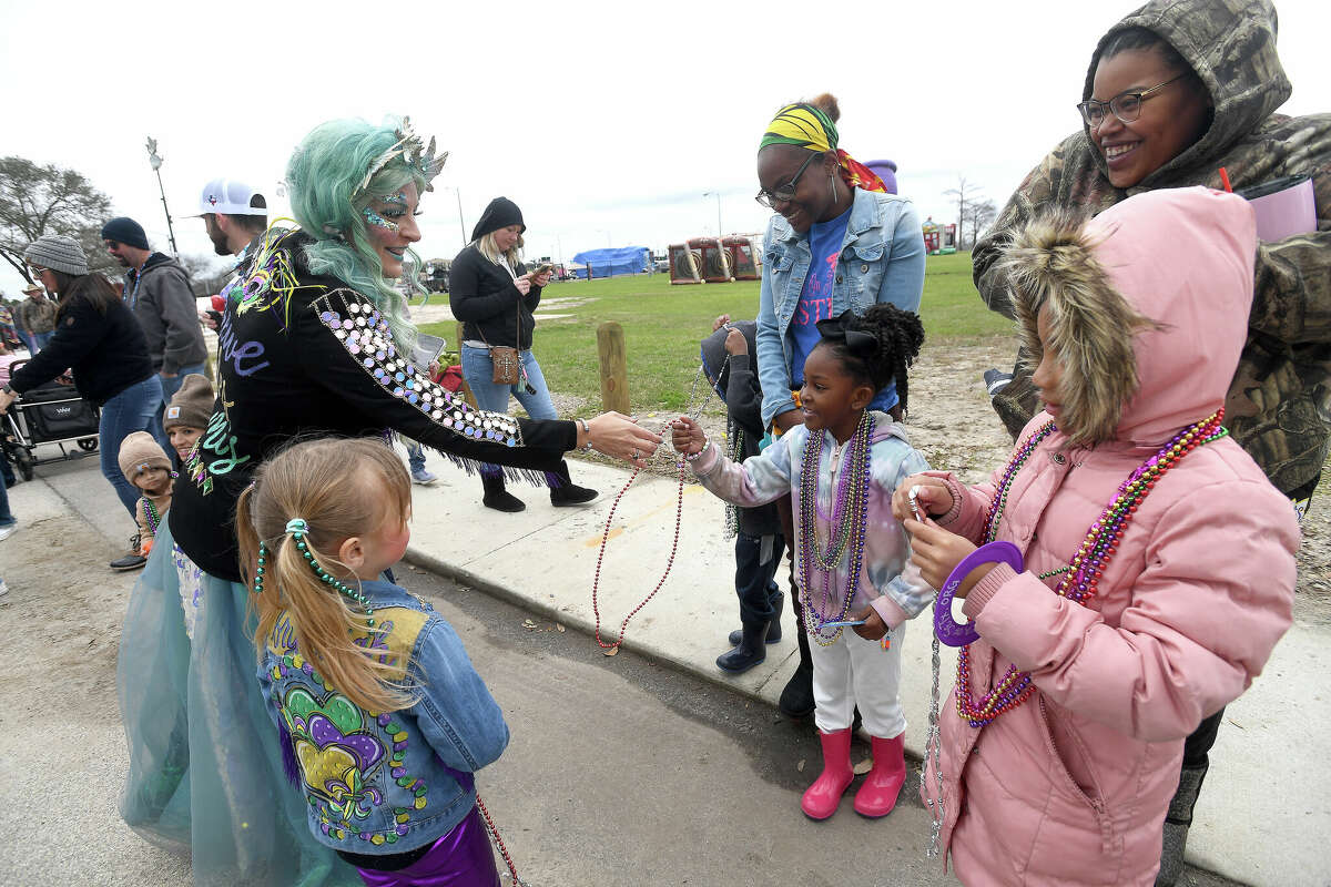 Lauren Stanley and daughter Brynleigh pass out beads and trinkets to the crowd during the Munchkin Parade as Mardi Gras on the Sabine gets underway Saturday in Orange. Photo made Saturday, February 11, 2023 Kim Brent/Beaumont Enterprise