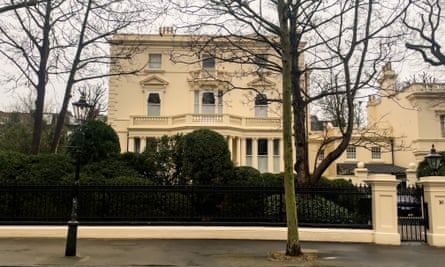 Photograph of a large and impressive, cream-painted detached mansion from the street