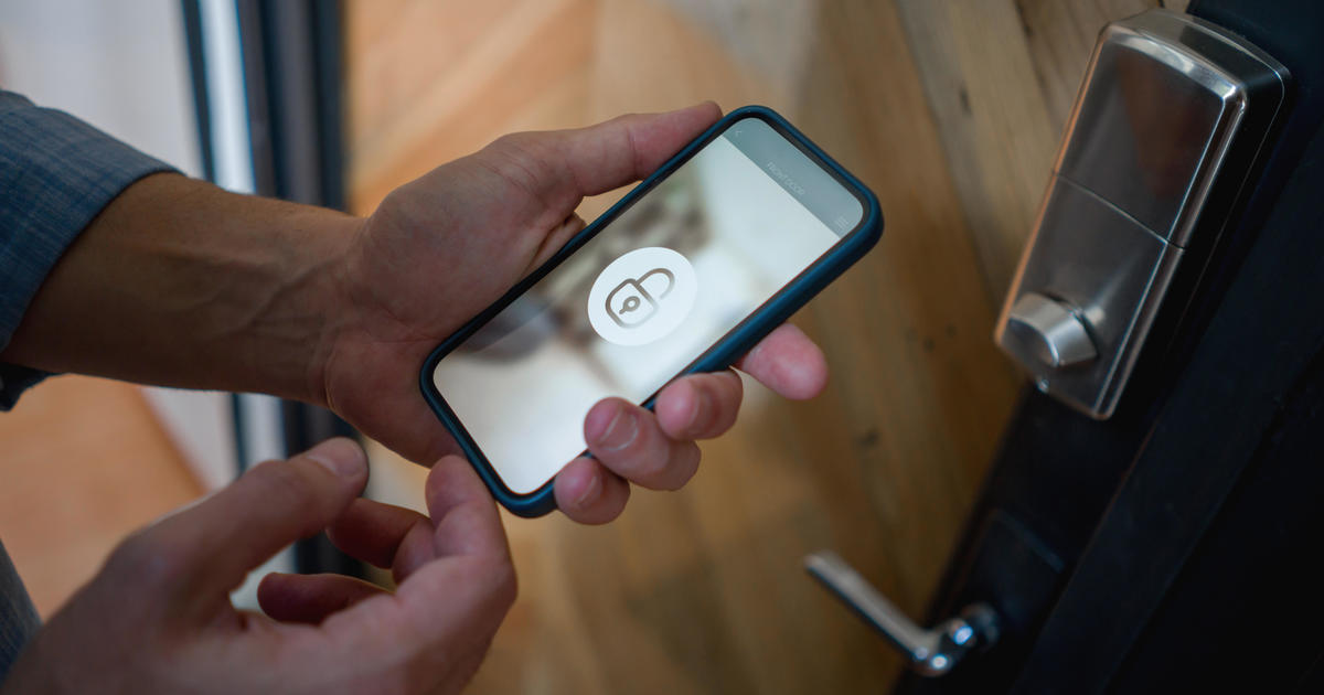 Man opening the door of his house using a home automation system 