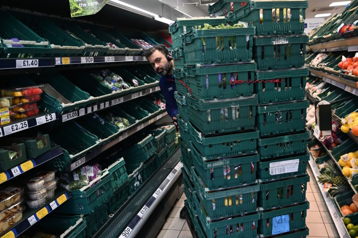 A supermarket worker loading shelves