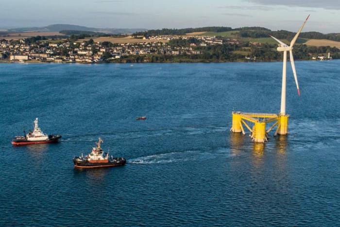 A floating wind turbine being towed into position of the coast of Aberdeen