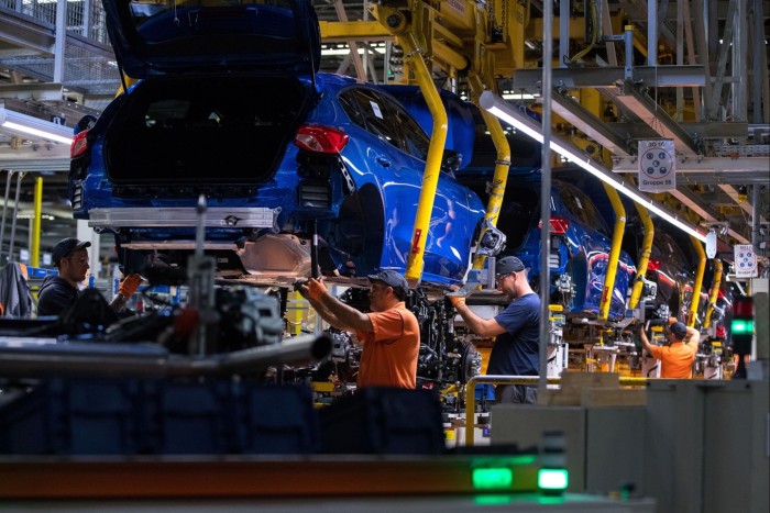 Workers fit automobile chassis at the Ford Motor factory in Saarlouis, Germany, in 2019