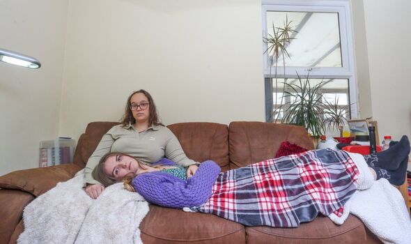 Two girls on a sofa, one led over the other's legs