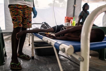 A relative visiting a patient in bed in a cholera centre in Lilongwe, Malawi.