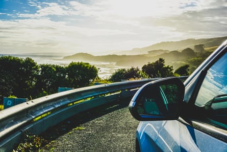 View of beach and hills from the Great Ocean Road with a car’s side mirror in view