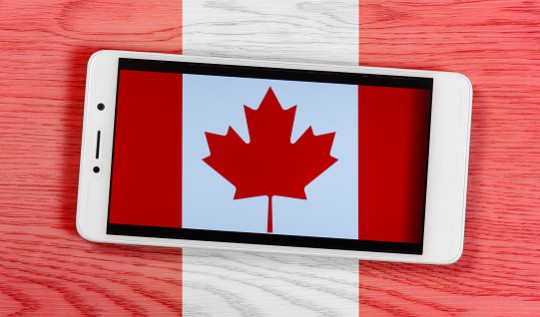 Canadian Flag Consisting of a Smartphone over a Wooden Background