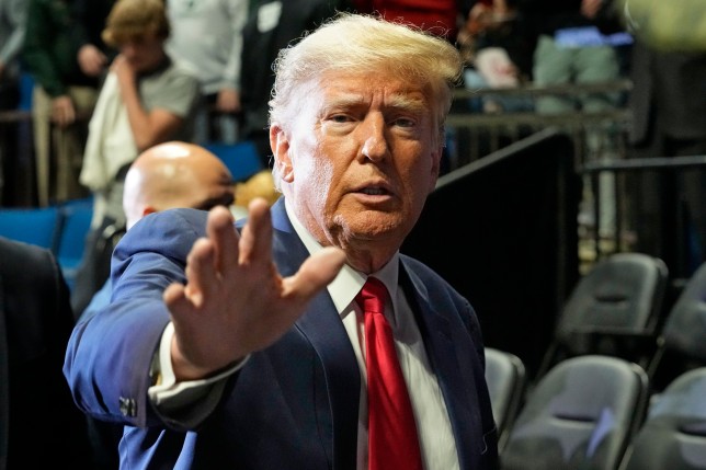 Former President Donald J. Trump waves as he arrives for the NCAA Wrestling Championships, Saturday, March 18, 2023, in Tulsa, Okla. (AP Photo/Sue Ogrocki)