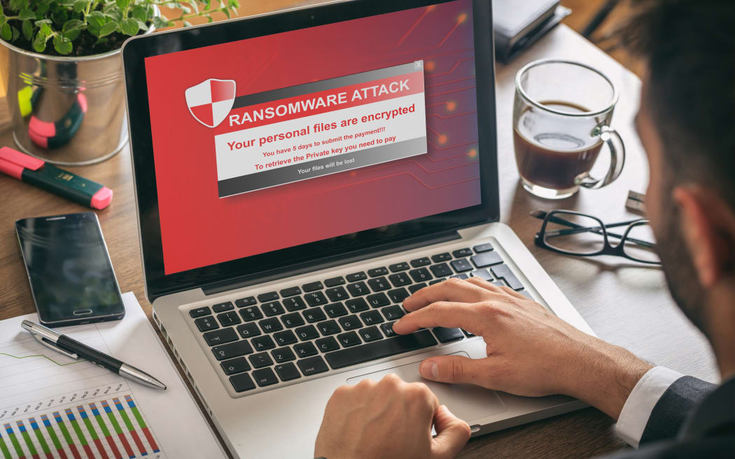 Ransomware alert message on a laptop screen - man at work