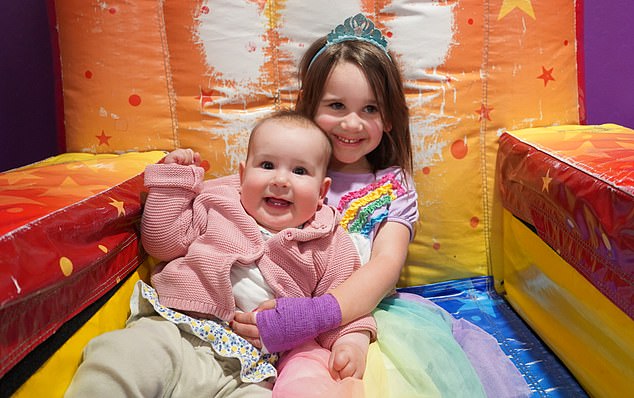 Lena had to have surgery on her hand five months after the bit itself after a rare, and never before seen, bacterial infection developed. Here she is pictured with a bandage following the operation alongside her baby sister Anna, who was born four months after the bite