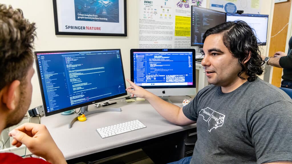 Fabio Urbina talks with someone off-camera as he talks through data shown on his computer screen.