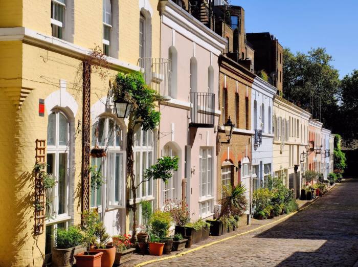 Colourful and sunny mews houses and flowers in the cobblestone lane Ennismore Garden Mews, Knightsbridge, London