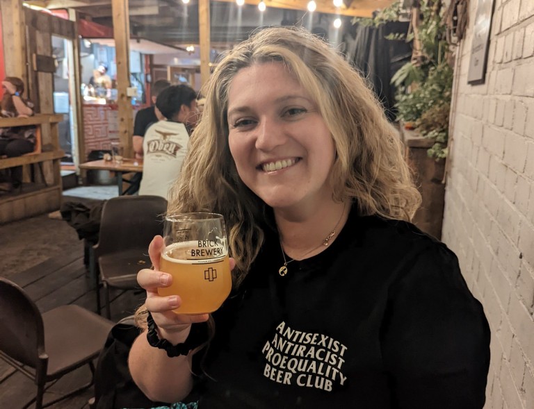 Emmie Harrison-West smiling with a beer in hand