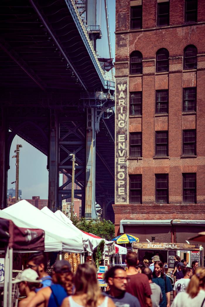 People mill around at a flea market in Dumbo