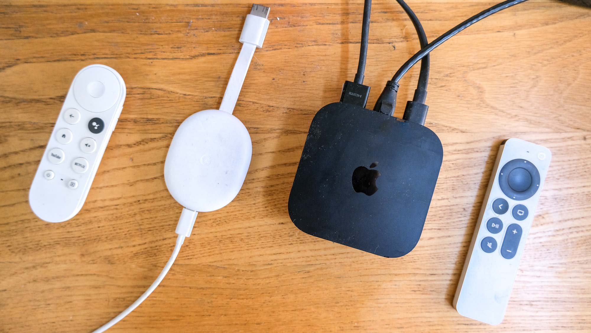 The Chromecast with Google TV alongside the Apple TV 4K 2022 home screen with an ad for Apple TV