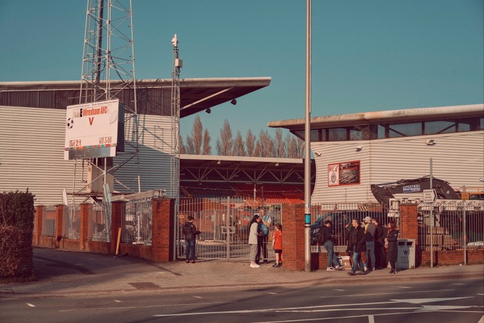 Fans stand by the gates with a view on to the stadium stands