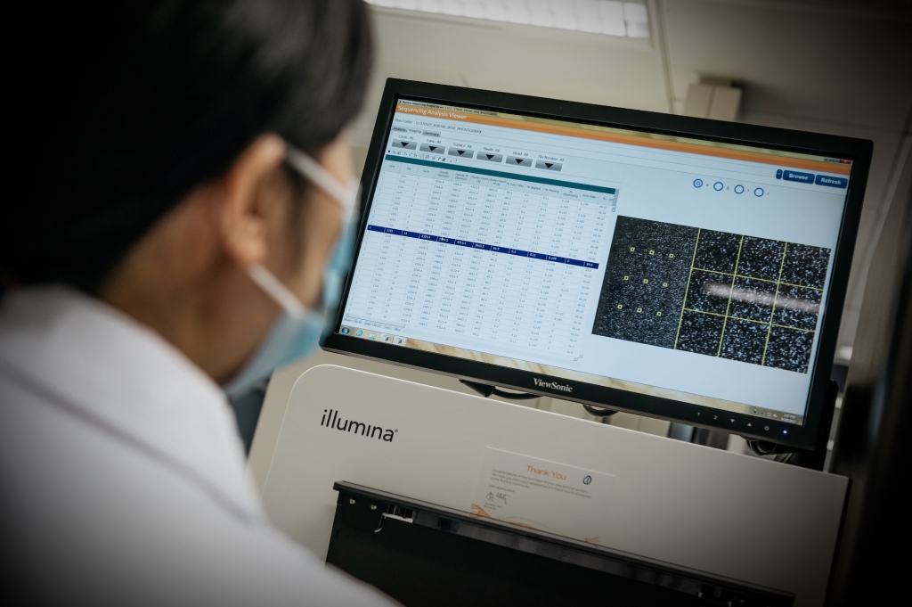 A technician looks at a monitor for an Illumina Inc. DNA sequencing machine inside the Plasma Nucleic Acids laboratory in China