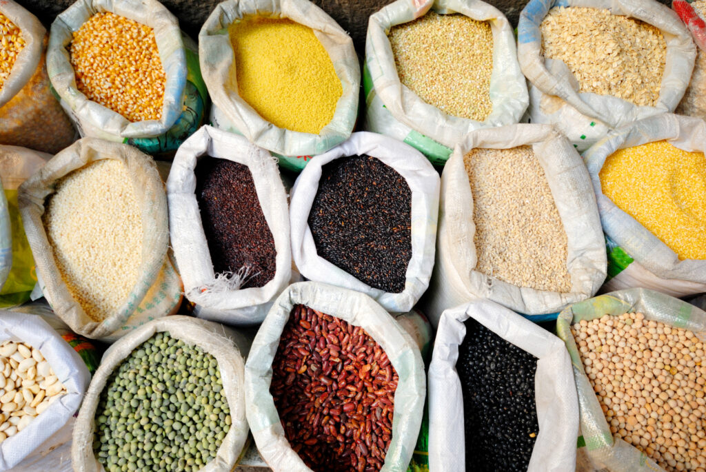 Various large white bags of grain opened at top to show contents.