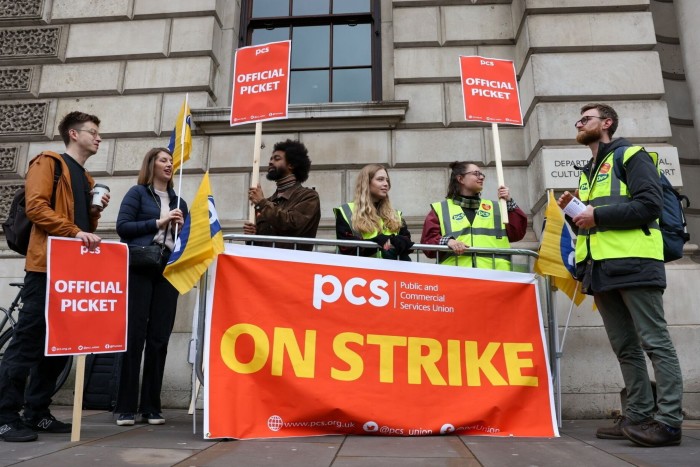 Civil servants on a picket line with a large poster that reads: ‘On strike’