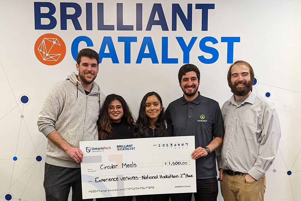 Ontario Tech's 2023 Experience Ventures National Hackathon team celebrating the second-place prize. From left:  Scott Dennis (third-year, Faculty of Business and Information Technology); Alizah Zaidi (fourth-year student, Faculty of Social Science and Humanities); Anupriya Dubey (third-year student, Faculty of Science); Nicholas Varas (fifth-year student, Faculty of Engineering and Applied Science); and Connor Loughlean (Manager of Creativity, Brilliant Catalyst, Ontario Tech University). Absent: Katherine Walduck (third-year student, Faculty of Business and Information Technology), and Michael Bondarenko (third-year student, Faculty of Science). 