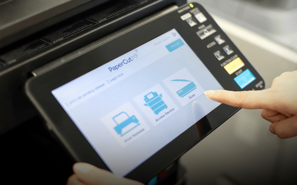 a photo of someone using a printer embedded with PaperCut's software