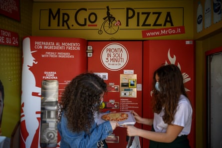 Two women with pizza from a vending machine