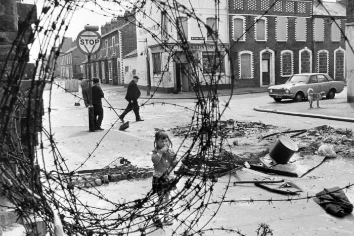 In this file photo taken on June 29, 1974 a little girl is seen in a street of the Belfast catholic area, looking at barbed wire, near a roadblock