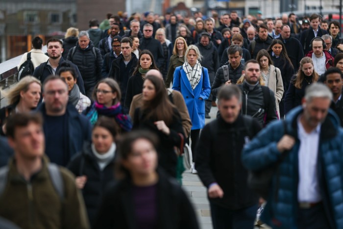 Commuters cross London Bridge in the City of London