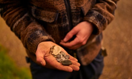 Tom Lucking’s hand holding coins and other metal objects