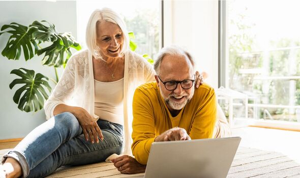 Couple smiling pointing at laptop