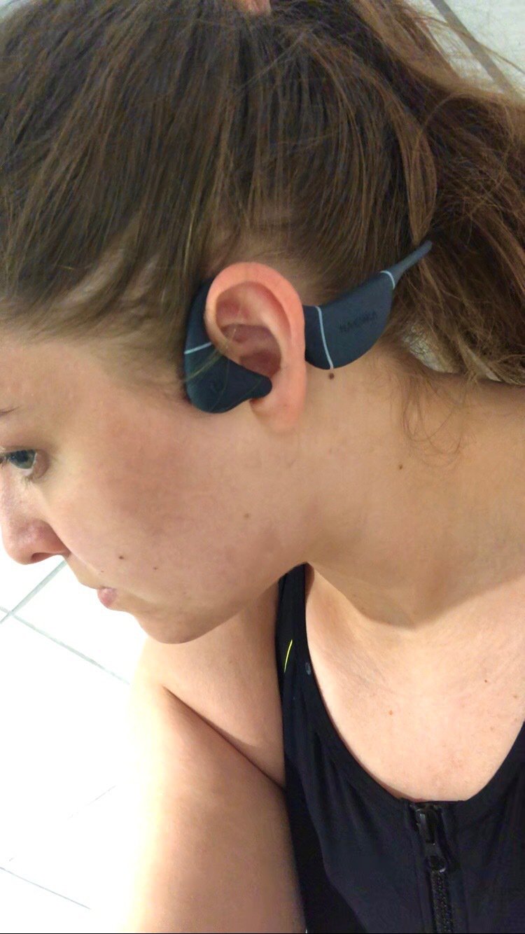 Emma Rossiter, a young woman with dark hair, poses with waterproof headphones in her ear