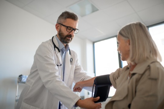 Doctor examining old woman