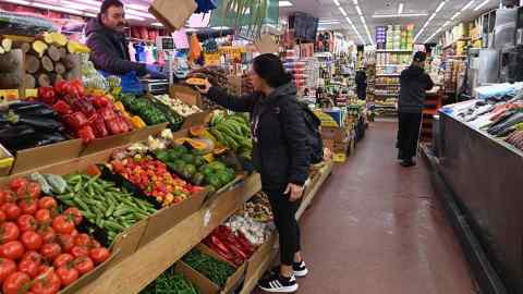 A customer buys fruit at a market in London