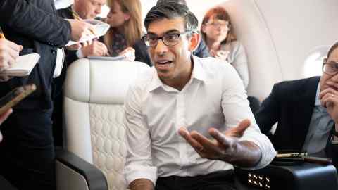 Rishi Sunak holds a huddle with political journalists on board a government plane as he heads to Japan to attend the G7 summit in Hiroshima on May 17