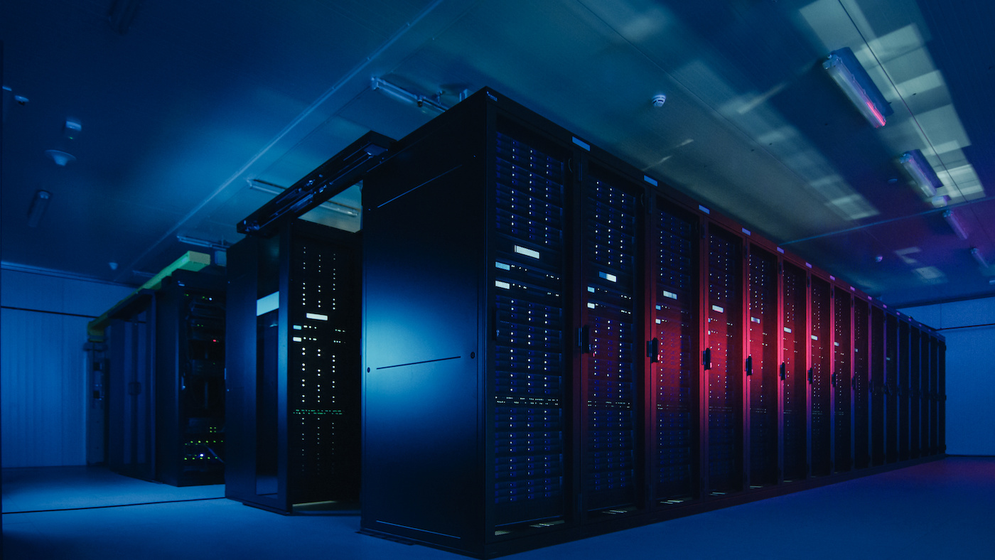 Dark room full of data servers backlit in blue and red